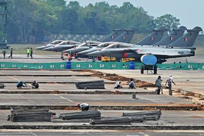 Obreros trabajan en la pista durante un ejercicio conjunto entre las Fuerzas Aéreas de la India y de Estados Unidos en la estación de la fuerza aérea en Kalaikunda, en el estado indio de Bengala Occidental, el 24 de abril de 2023. 