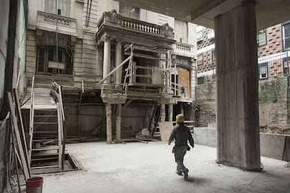 Obreros trabajan en la reconstrucción de la casa y en el edificio de adelante