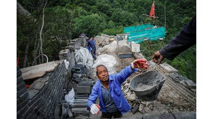 Obreros trabajando en la reconstrucción de la sección Jiankou de la Gran Muralla, ubicada en el distrito de Huairou, al norte de Pekín