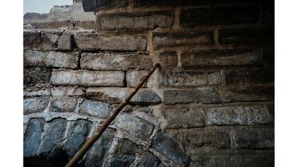 Un ingeniero apunta a la línea entre la parte vieja (izquierda) y las construidas recientemente de la sección de Jiankou de la Gran Muralla