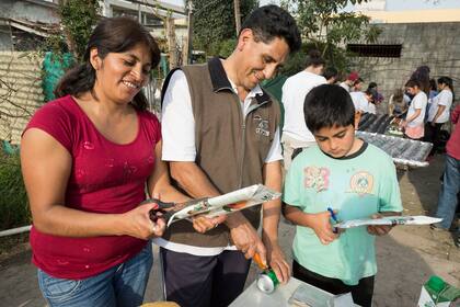 Ofelia y César Flores, junto a una de sus hijos, colaboran en la construcción del calefón
