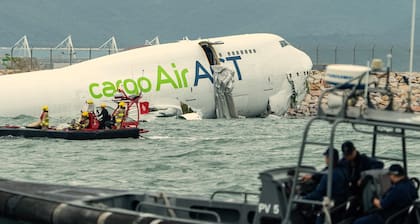Oficiales aeroportuarios auxilian al Boeing tras el accidente en Hong Kong