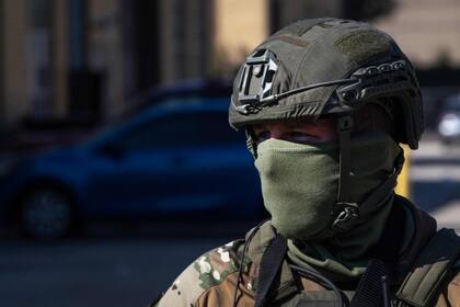 Oficiales del Servicio de Control de Inmigración y Aduanas (ICE) vigilan en medio de protestas para asegurar un área frente a una instalación en Chicago