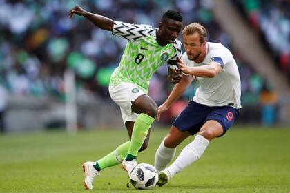 Oghenekaro Etebo de Nigeria elude a Harry Kane de Inglaterra
