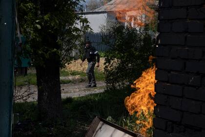Oleg, un trabajador de la construccin convertido en voluntario, camina junto a una casa en llamas mientras busca a los residentes para evacuar en Ruska Lozova, Ucrania, el mircoles. (Tyler Hicks/The New York Times)