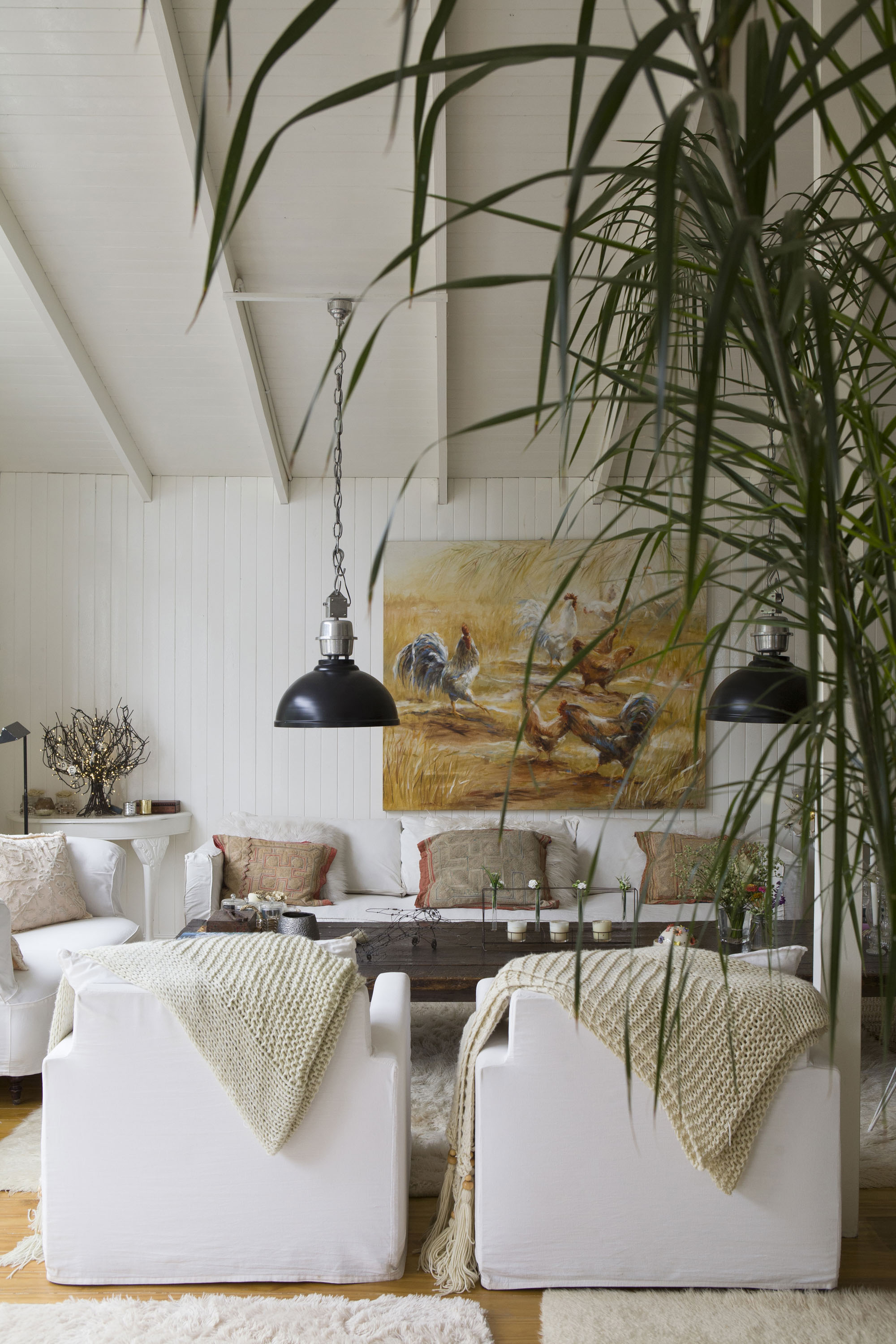 Óleo de Claudia Lucini y almohadones hechos con géneros antiguos traídos de Laos. Las lámparas galponeras son de Landmark.