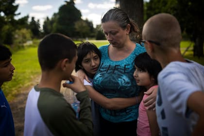 Olga Lopatkina abraza a sus hijos adoptivos en un parque de Loue (Francia) el 2 de julio del 2022. Lopatkina se separó de los chicos en medio de la guerra en Ucrania y los niños fueron llevados a Rusia. Pero luego de arduas negociaciones logró reunirse nuevamente con ellos. (AP Photo/Jeremías González)