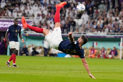 Olivier Giroud, goleador francés, ensaya una pirueta durante el partido de octavos de final de Qatar 2022 ante Polonia; el futbolista de Milan (Italia) podría perderse la final ante Argentina por un problema físico