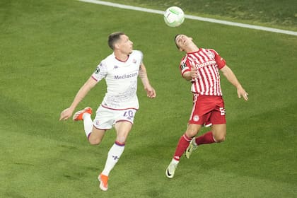Olympiacos' Daniel Podence, right, jumps for a header with Fiorentina's Andrea Belotti during the Conference League final soccer match between Olympiacos FC and ACF Fiorentina at OPAP Arena in Athens, Greece, Wednesday, May 29, 2024. (AP Photo/Petros Karadjias)�