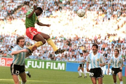 Omam-Biyik ya ganó en lo alto: será el 1-0 de Camerún ante Argentina; abajo, Sensini, Simón y Lorenzo