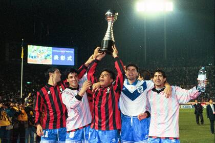 Omar Asad levanta la Copa Intercontinental en medio de los festejos de Vélez tras la final con Milan en 1994 en Japón.