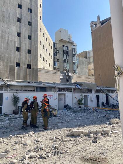 Operarios entre cascotes y otros restos tras la caída del misil iraní