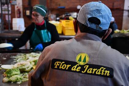 Operarios procesan hortalizas para los encurtidos, otro clásico de la cooperativa. Foto: Martín Ghisio (INTA)