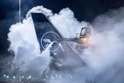 Operarios retiran el hielo de un avión de Lufthansa en el aeropuerto de Frankfurt, Alemania.
