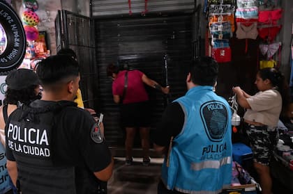 Operativo en la 1.11.14: efectivos de la Policía de la Ciudad supervisan el cierre de un comercio durante un procedimiento vinculado a narcomenudeo