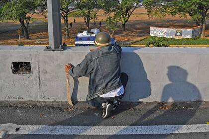 Opositores al gobierno de Maduro observan desde un puente en Caracas