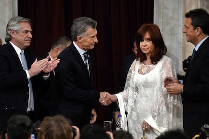 El presidente saliente Mauricio Macri saluda a la vicepresidenta electa Cristina Fernández de Kirchner antes de retirarse de la ceremonia donde entregó los at