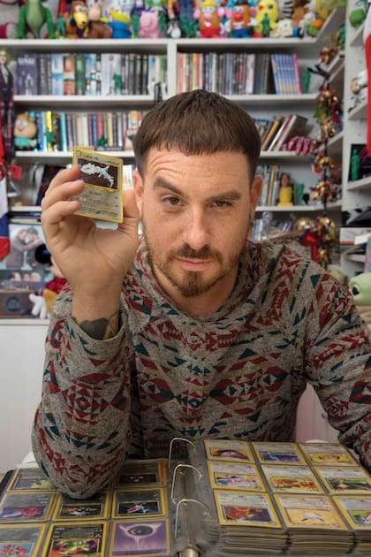 Orgulloso, muestra su álbum de cartas de Pokémon, que tiene desde que era chico.