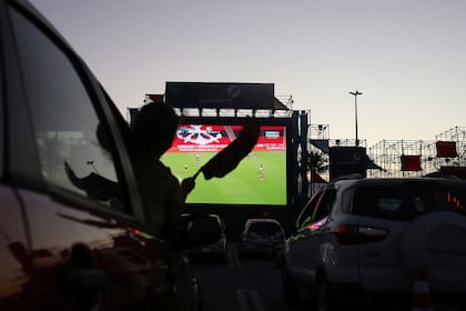 Los fanáticos del fútbol de Flamengo ven el partido del Campeonato Brasileiro entre Flamengo y Atlético Mineiro desde autos durante un autocine, en Río de Janeiro