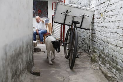 Oscar en el pasillo de entrada a su casa, con Rosalía, su perra.