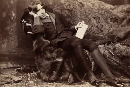 Oscar Wilde reclinado con su libro Poemas