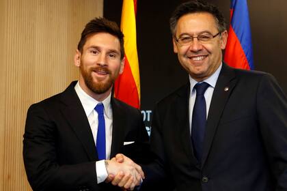 Otros tiempos: Lionel Messi y Josep María Bartomeu se daban la mano. El rosarino le indicó hoy al club que se ampara en una cláusula unilateral de su contrato para dejar el club un año antes del final del convenio.