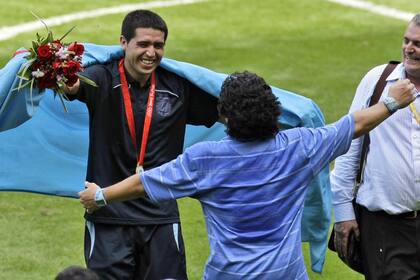 Otros tiempos: Riquelme y Maradona, a punto de abrazarse. Fue el día que la selección ganó la medalla de oro en Pekín 2008, con el 10 como símbolo y Diego en un rol de asesor del equipo técnico que comandaba Batista.