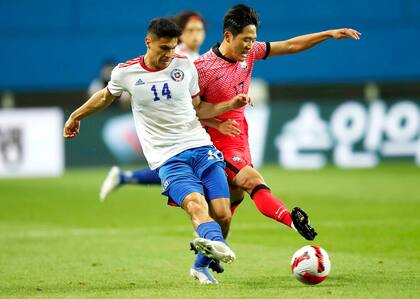 Pablo Galdames y Na Sang-ho luchan por la pelota durante el partido que disputaron Corea del Sur y Chile.