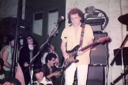 Pablo Guyot, guitarrista emblemático del rock nacional, en el escenario de La Esquina del Sol; atrás, el vidrio de la puerta que rompió "el gordo Pierre" y un joven Fito Páez esperando su momento para subir a tocar