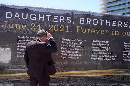 Pablo Langesfeld mira el nombre de su hija Nicole Langesfeld en una manta con los nombres de las personas fallecidas en el condominio Champlain Towers South