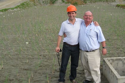 Pablo Puyal y Ronald Lavigne parados en un pantano seco de tratamiento de cianuro de una mina de oro
