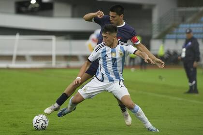 Pablo Solari, autor del primer gol de la Argentina ante Paraguay, con la marca del capitán Diego Gómez; el delantero pidió realizar una autocrítica ante la falencia de manejar el resultado