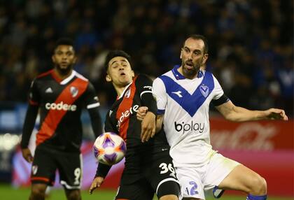 Pablo Solari forcejea con Diego Godín; Vélez reaccionó dos veces a la desventaja y logró un agónico empate con River