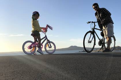 Padre e hija aprovechan para pasear en bici en este período especial.