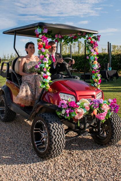 Padre e hija llegaron hasta el lugar de la ceremonia a bordo de un carrito de golf intervenido con flores naturales.