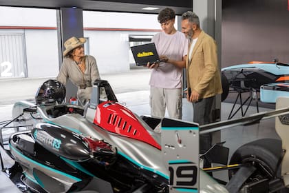 Padre e hijo atentos a los detalles del auto F3 Sudamericano, marca Dallara, con motor Berta F3, que ambos manejan. Para conducirlo se someten a un duro entrenamiento y bromean con Karina, que confiesa que no entiende absolutamente nada del auto.