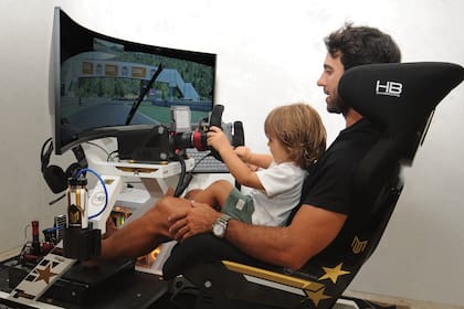 Padre e hijo, divertidos en el simulador, que replica las condiciones de manejo en una pista de manera virtual