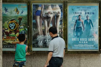 Padre e hijo observan carteles de películas extranjeras afuera de un cine en Pekín. Hollywood ha moldeado durante mucho tiempo los gustos y preferencias del público chino