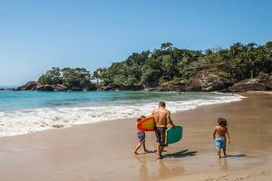 Padre e hijos en la orilla de praia Félix en Ubatuba.
