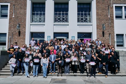 Padres colaboradores de ArcelorMittal Acindar junto a sus hijos becados, durante la entrega de becas. Planta de Villa Constitución.