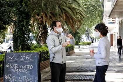 Un papá comparte una bebida con su hijo: el sol del sábado apuró las salidas