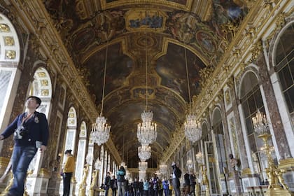 Visitantes caminan dentro del Salón de los Espejos en el castillo de Versalles, el 17 de noviembre de 2015 en Versalles, al oeste de París