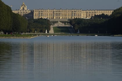 El castillo de Versalles aparece al atardecer con el Gran Canal en primer plano en Versalles