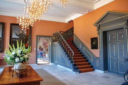 Al salón le dieron calidez con color y sumaron ornamentos como una alfombra, una gran mesa de madera, pinturas y dos globos terráqueos.