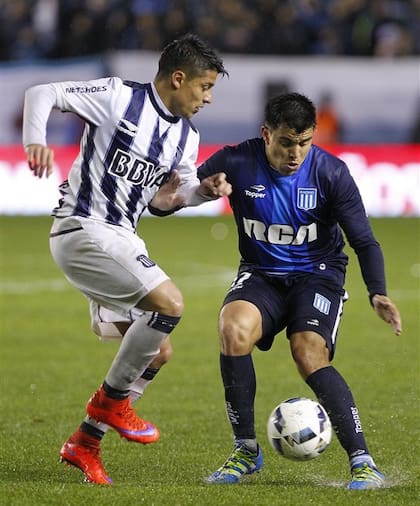 Palacios frente a Acuña; el de Racing anotó el empate de tiro libre