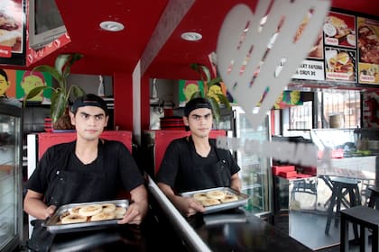 Palermo: Eduard Meléndez sostiene una bandeja con arepas, una delicia típica de su país, Colombia