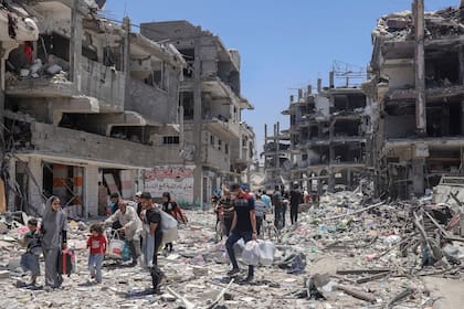 Palestinos caminan en medio de la destrucción causada por los bombardeos de Israel en Jebaliya, al norte de la Franja de Gaza, el 30 de mayo de 2024