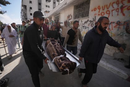 Palestinos cargan con el cuerpo de una persona fallecida en la víspera en ataques aéreos israelíes contra Izz al-Din al-Haddad, líder de las Brigadas Qassam de Hamas, durante un funeral en el exterior del hospital Shifa, en la Ciudad de Gaza, el 16 de mayo de 2026
(AP Foto/Jehad Alshrafi)