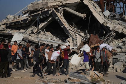 Palestinos cargan paquetes de ayuda distribuidos por la Fundación Humanitaria de Gaza, operada por una organización respaldada por EEUU, en Jan Yunis, en el sur de la Franja de Gaza, el 26 de junio de 2025. (AP Foto/Abdel Kareem Hana)