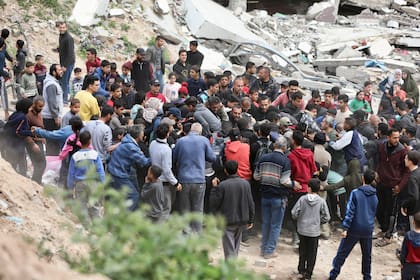 Palestinos corren para recoger ayuda humanitaria lanzada desde el aire en Ciudad Gaza, Franja de Gaza, el 17 de marzo de 2024